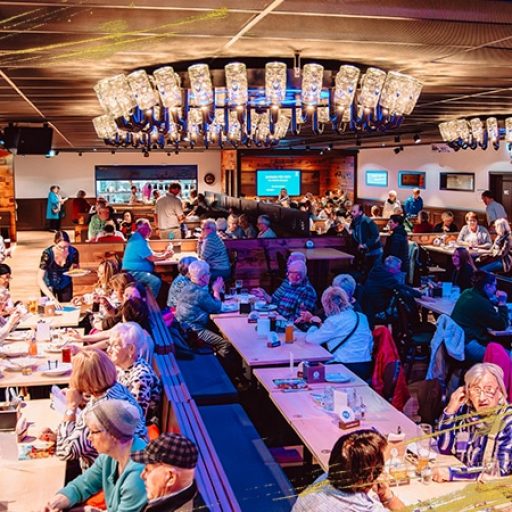 Volle Markthalle im Königshof Essen mit Gästen, die gemeinsam essen, trinken und die lebendige Atmosphäre genießen.